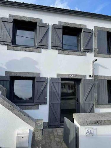 a white building with brown doors and windows at Casa da Esquila Ilha do Pico 2 in Cais do Pico
