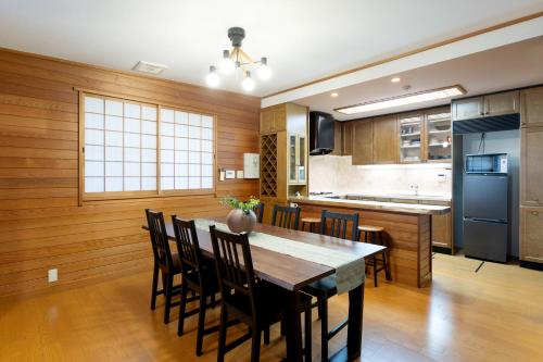 a kitchen and dining room with a table and chairs at Hakone Sengokuhara Soubokuan 箱根仙石原 相睦菴 in Sengokuhara