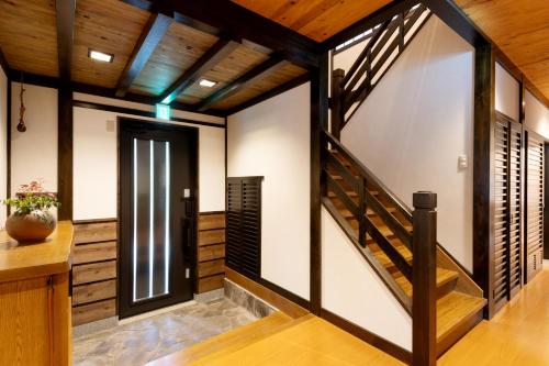 a hallway with wooden walls and a staircase in a house at Hakone Sengokuhara Soubokuan 箱根仙石原 相睦菴 in Sengokuhara