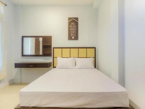 a bedroom with a large white bed and a mirror at OYO Life 2354 Rose House in Medan