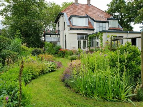 an old house with a garden in front of it at B&B Slapen bij de burgemeester in Sint Pancras