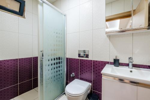 een badkamer met een toilet, een wastafel en een douche bij Flat w Balcony 5 min to Beach in Kemer in Antalya