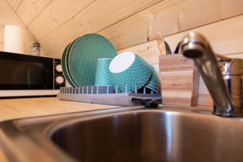 um balcão de cozinha com um lavatório e um suporte para facas em La cabane magique em Conty