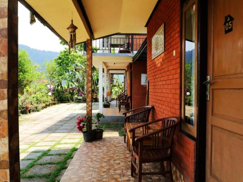 an open door of a house with chairs and a patio at Dajan Buyan Homestay in Bedugul