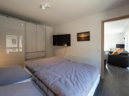 um quarto com uma cama e uma televisão na parede em Jade Glück Wilhelmshaven em Wilhelmshaven