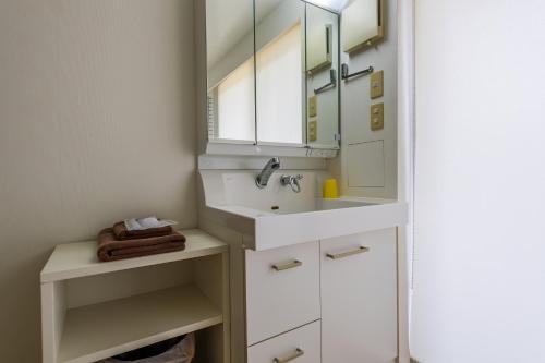 a bathroom with a sink and a mirror at HOTEL E-horizon Resort コンドミニアム瀬底 in Motobu