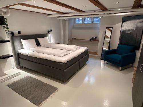 sypialnia z łóżkiem i niebieskim krzesłem w obiekcie PSG 23 - Short Stay Apartments by Living Suites w Kopenhadze
