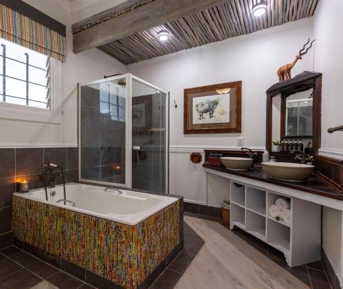 a bathroom with a large tub and a shower at Seaforth Country House in Ballito