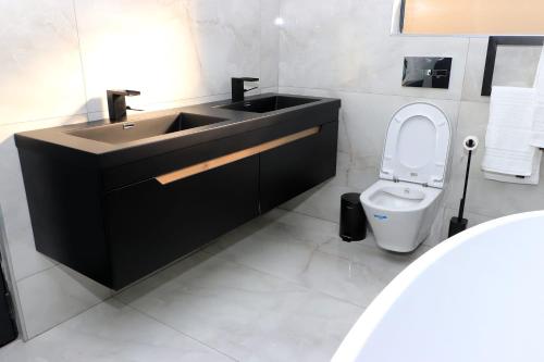 uma casa de banho com um lavatório e um WC em The Residence Villa em Musina