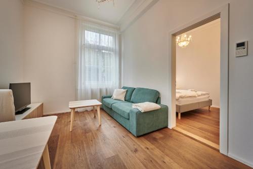 sala de estar con sofá verde y cama en Perfect Location, comfortable & modern en Berna