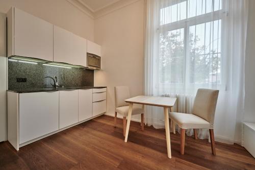 伯恩的住宿－Perfect Location, comfortable & modern，厨房配有白色橱柜和桌椅