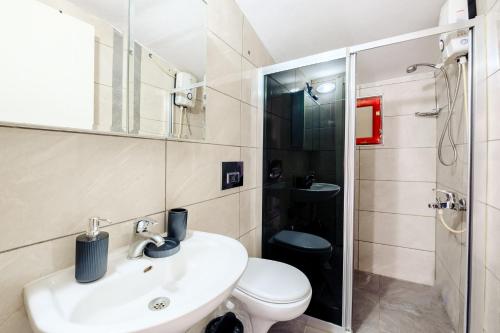 een badkamer met een wastafel, een toilet en een douche bij Nature View Flat w Terrace 5 min to Beach in Kemer in Antalya