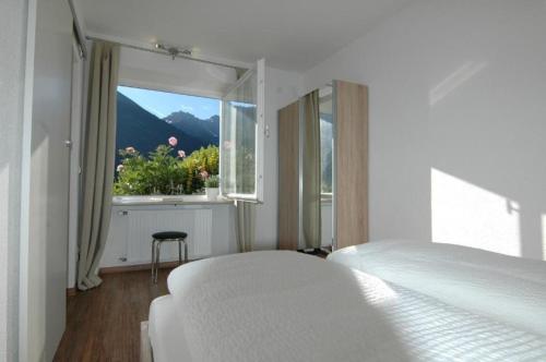 a bedroom with a bed and a window with a view at Mittelberg Ferienwohnung in Mittelberg