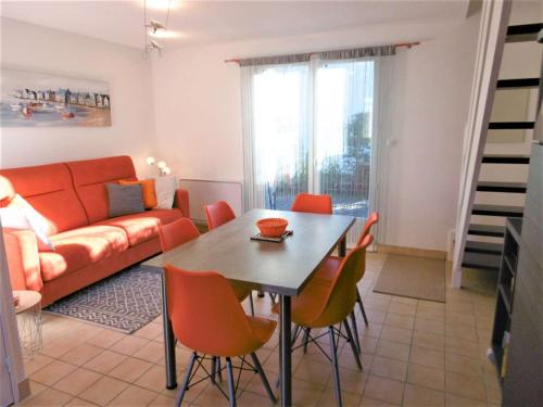 un salon avec une table, des chaises et un canapé dans l'établissement Maisonnette JIKEL à 50 m de la plage, à Sarzeau