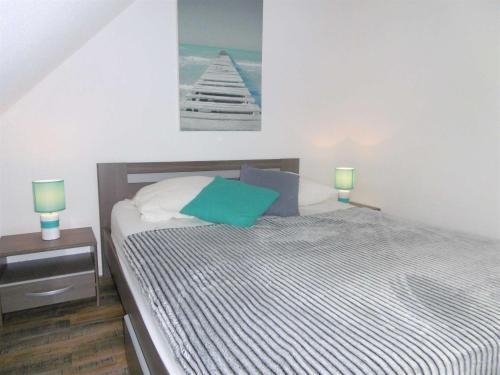 a bedroom with a bed with a green pillow and two lamps at Maisonnette JIKEL à 50 m de la plage in Sarzeau