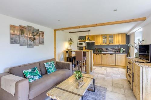 un salon avec un canapé et une table dans l'établissement Gîte de charme : La grange au lac Azur, à Treffort