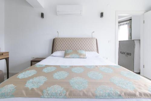 a bed with a blanket on top of it at Gokceada Marmaros Butik Otel in Gokceada Town