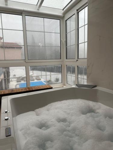 a bath tub filled with snow in a room with windows at Holiday Home Korda in Čapljina