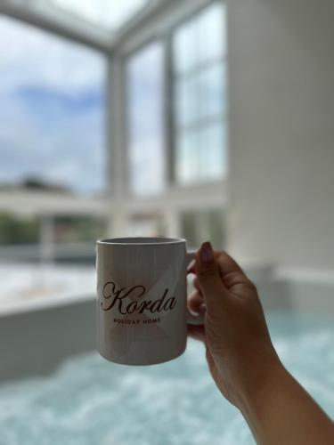 a person holding a coffee mug with their hand at Holiday Home Korda in Čapljina