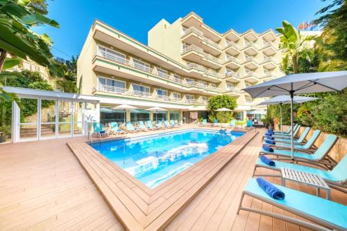 una piscina en un hotel con tumbonas y sombrillas en Hotel Agua Beach "Adults only" en Palmanova