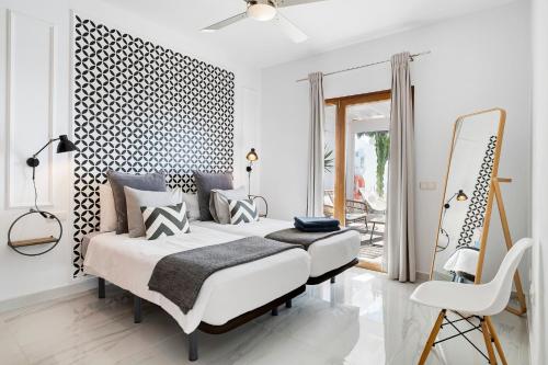 プラヤ・ブランカにあるVilla El Anclaのベッドと鏡のある白い寝室