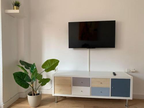 uma sala de estar com televisão numa parede branca em Cozy 3bd near vibrant Valencia em Paiporta