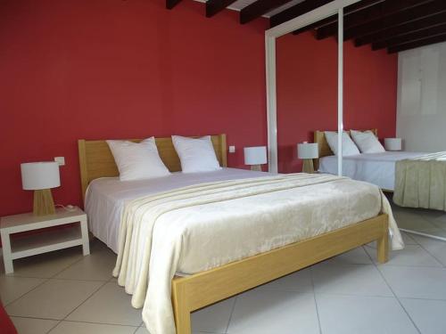 ein Schlafzimmer mit einem großen Bett und einer roten Wand in der Unterkunft Gite un bren de bonheur in Bren