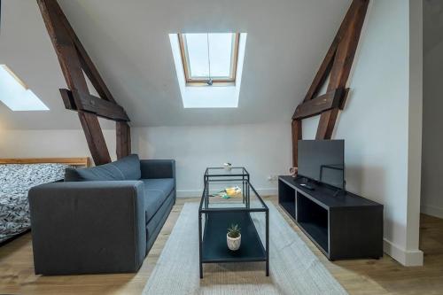 un salon avec un canapé et une télévision dans l'établissement Le Refuge Palois, à Pau