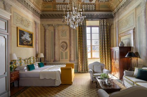 een slaapkamer met een groot bed en een kroonluchter bij Grand Hotel Continental Siena - Starhotels Collezione in Siena