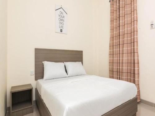 1 dormitorio con 1 cama grande con colcha blanca en OYO Life 2735 Graha Nirwana en Tanjungriau