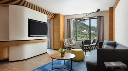 a living room with a couch and a tv at Hong Kong Ocean Park Marriott Hotel in Hong Kong