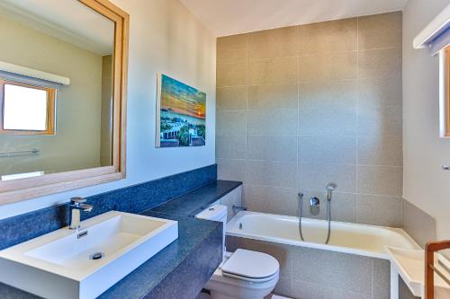 La salle de bains est pourvue d'un lavabo, d'une baignoire et de toilettes. dans l'établissement 23 Pyrgos, Santorini, Ballito, à Ballito