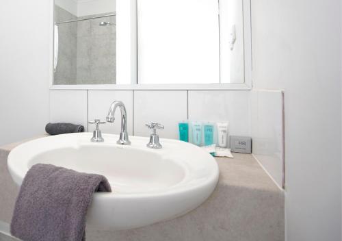 bagno con lavandino bianco e specchio di Kimberley Croc Motel a Kununurra