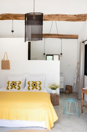 une chambre avec un lit avec un couvre-lit jaune dans l'établissement La Grange de Fer - Maison de caractère piscine privée, à Saint-Ferréol-Trente-Pas