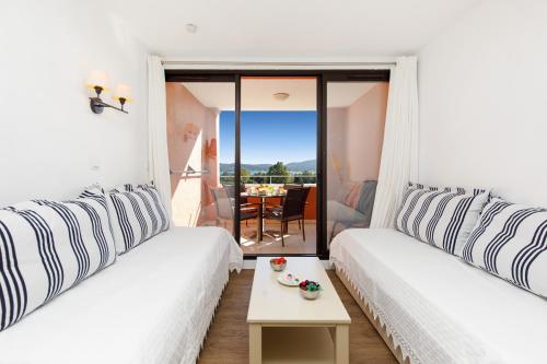 Cette chambre comprend 2 lits et une table avec vue. dans l'établissement Les Parcs De Grimaud YourHostHelper, à Grimaud