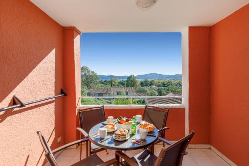 une salle à manger avec une table et des chaises sur un balcon dans l'établissement Les Parcs De Grimaud YourHostHelper, à Grimaud