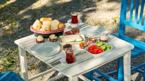 a table with a tray of food and fruit on it at Gokceada Marmaros Butik Otel in Gokceada Town
