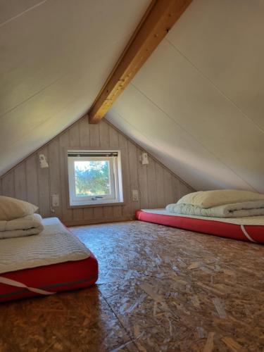 a attic room with two beds and a window at Rødvig Ferieby in Rødvig