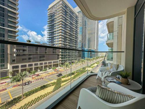 a balcony with white chairs and a view of a city at HiGuests - Emaar Beachfront Haven with Majestic Marina Views in Dubai