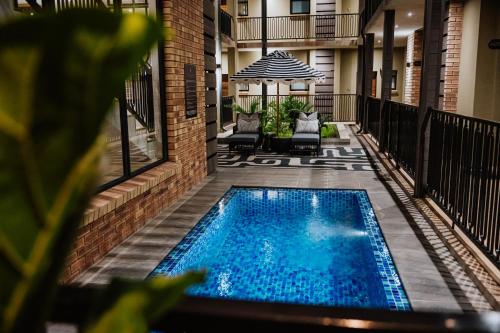 a swimming pool in the courtyard of a building at Oryx Boutique Hotel in Klerksdorp