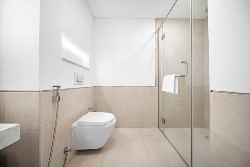 La salle de bains est pourvue de toilettes et d'une douche en verre. dans l'établissement Chic 1BR APT Rahaal 2 MJL, à Dubaï