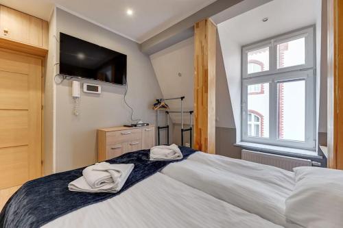 um quarto com uma cama grande com duas toalhas em Selve Sentrum by Grand Apartments em Sopot