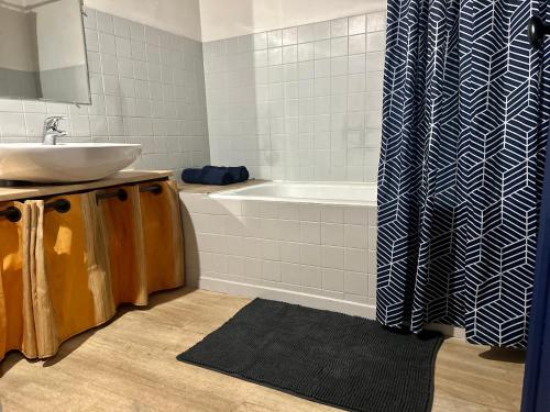 y baño con lavabo y bañera. en Le COSY de Mercadet - Parking gratuit & Wifi, en Perpiñán