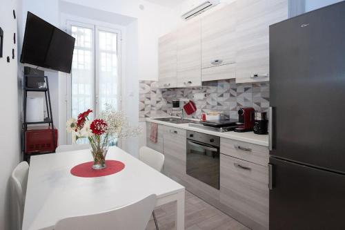 a kitchen with a white table and a black refrigerator at B&B Easy Apartment in Rome
