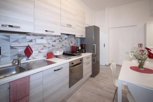 cocina con armarios blancos, fregadero y mesa en B&B Easy Apartment, en Roma
