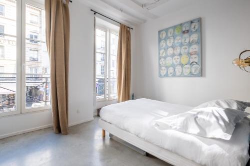 une chambre blanche avec un lit et une fenêtre dans l'établissement Veeve - Bright Beams, à Paris