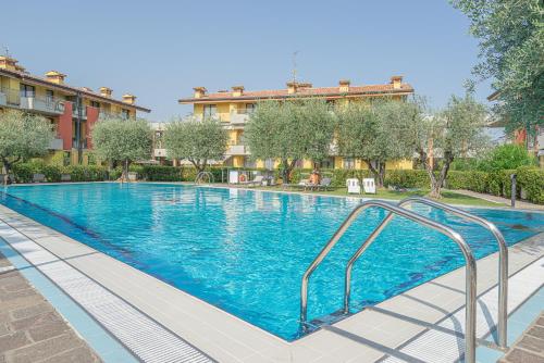 a swimming pool with blue water in a building at Dolce Vita Family Apartment in Sirmione