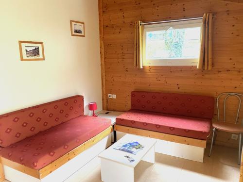 a room with two red benches and a window at Gites du Quié in Les Cabannes