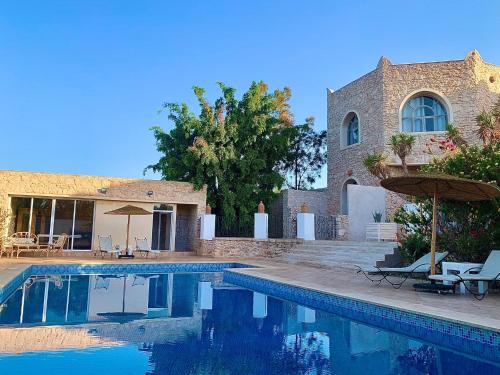 una piscina frente a una casa en Le Domaine d'Eden - Villa luxueuse, piscine, spa et personnel, en Essaouira