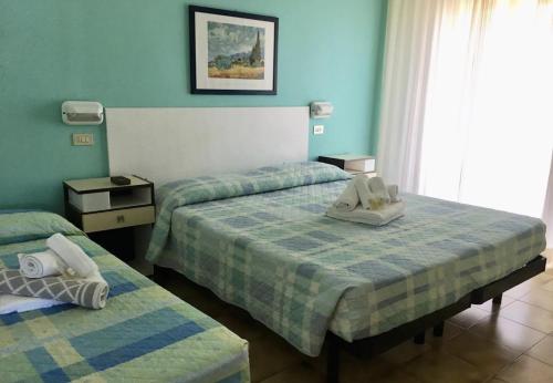 una camera con due letti e asciugamani di Hotel Bonaria a Rimini